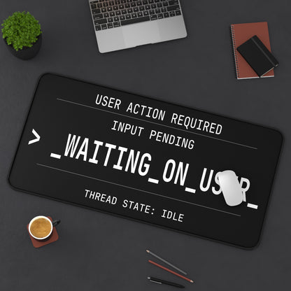 Black mouse pad with text design on a desk with laptop and coffee cup.